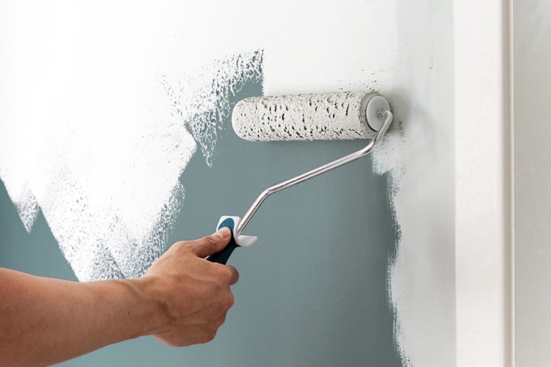 painting a wall with a roller